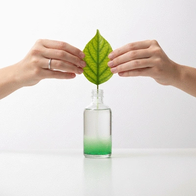 Hands holding a green leaf over a small bottle of eco-friendly cleaning product, symbolizing environmental care, bright and clean, no text, no words, no typography, no labels, clean image